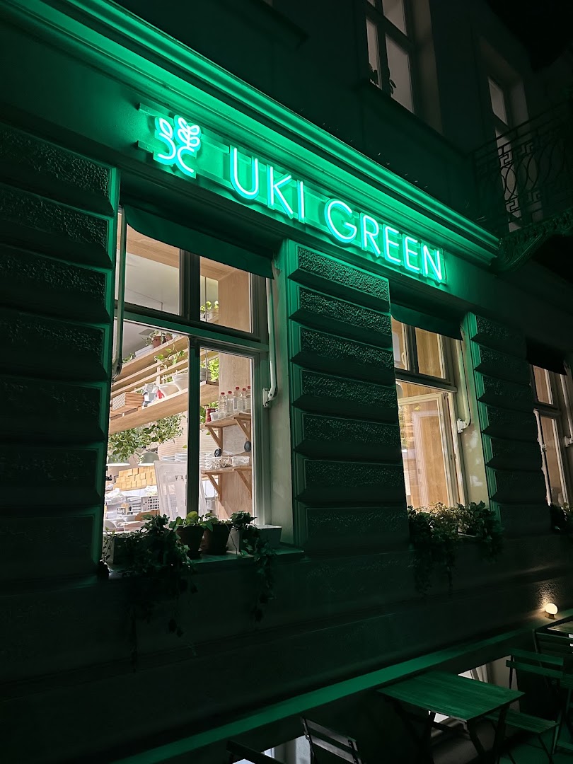 Witryna Uki Green nocą z zielonym neonem